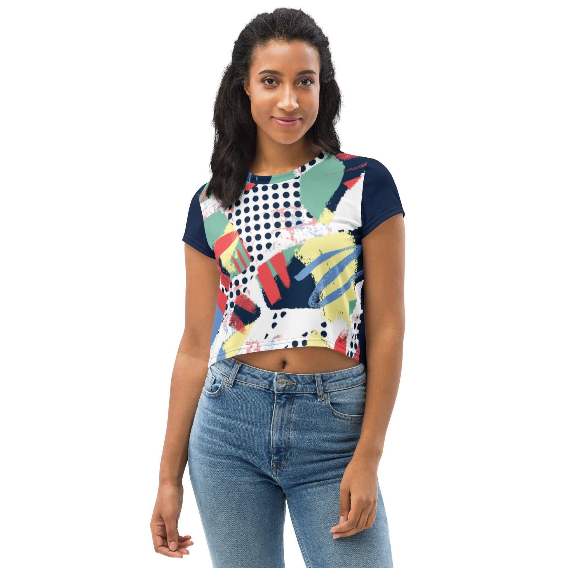 woman wearing 90's inspired crop tee with colorful abstract print and navy sleeves paired with blue jeans