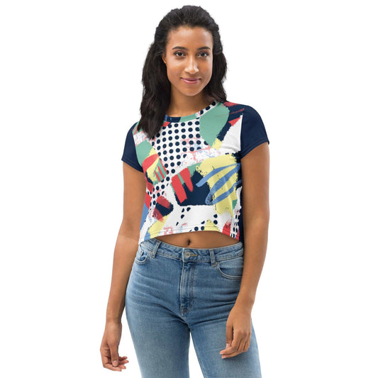 woman wearing 90's inspired crop tee with colorful abstract print and navy sleeves paired with blue jeans