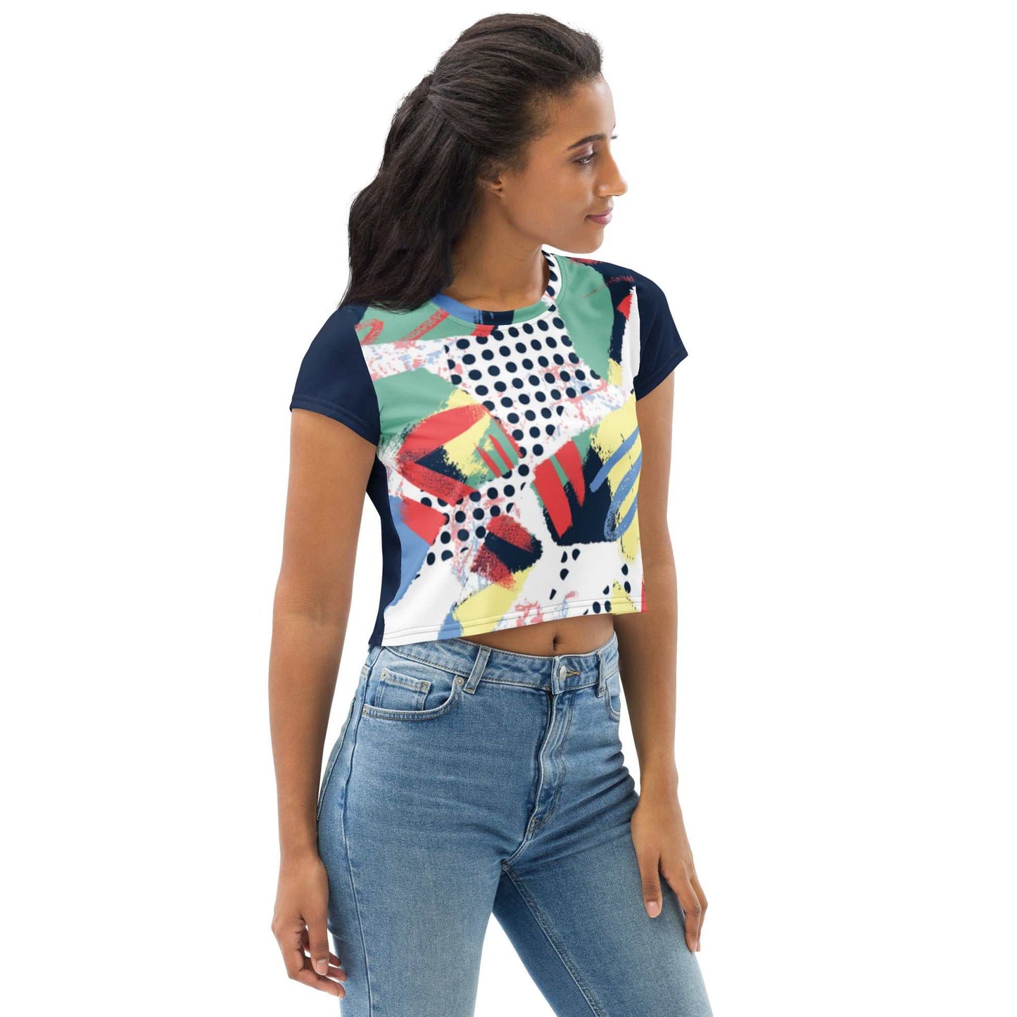 Woman wearing a 90's inspired crop tee with colorful abstract patterns and navy sleeves paired with blue jeans